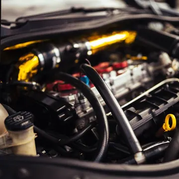 Car engine and mechanical components under an open bonnet