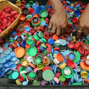 Mixed plastic bottle caps being sorted by hand